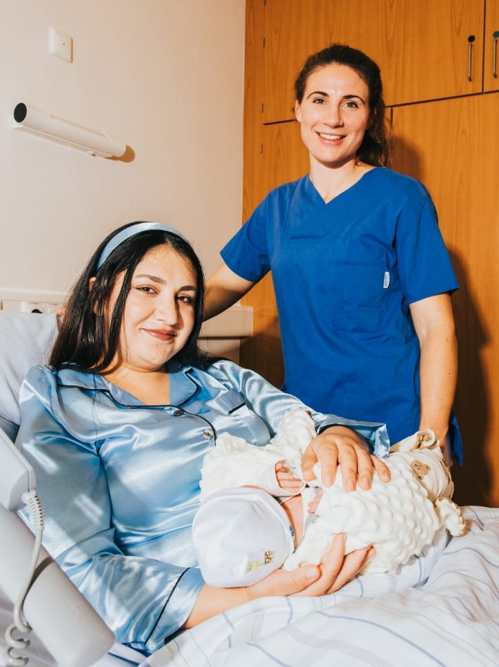 Hebamme im DIAKO mit Mutter und Neugeborenem