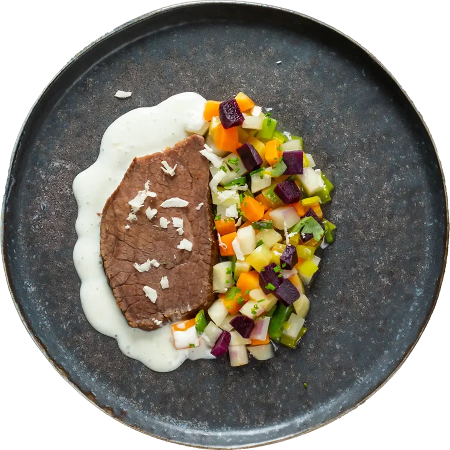 Teller mit Braten, Gemüse und Püree von oben