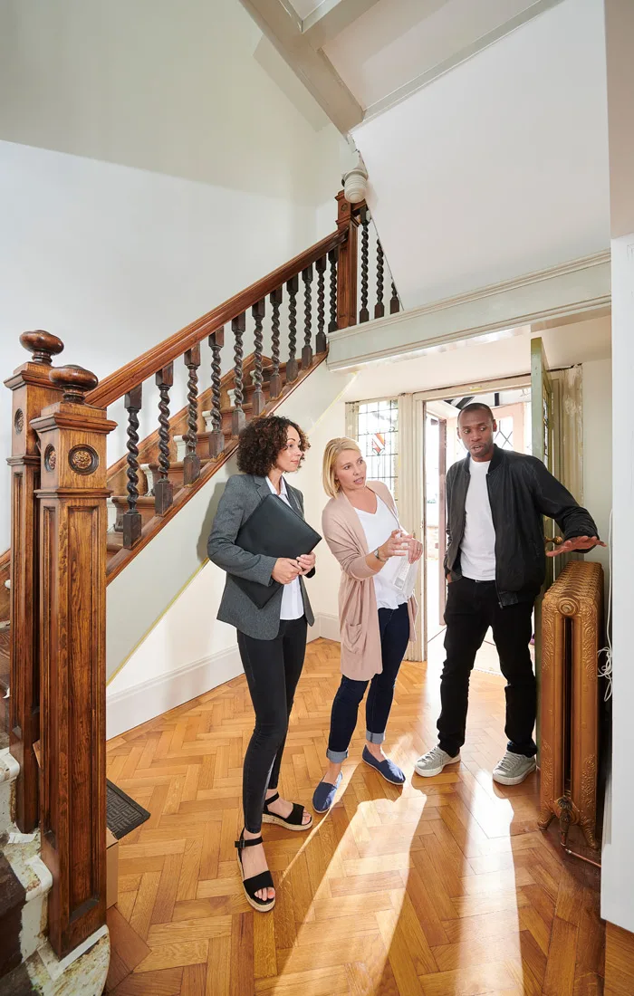Makler führt Interessenten durch ein Haus
